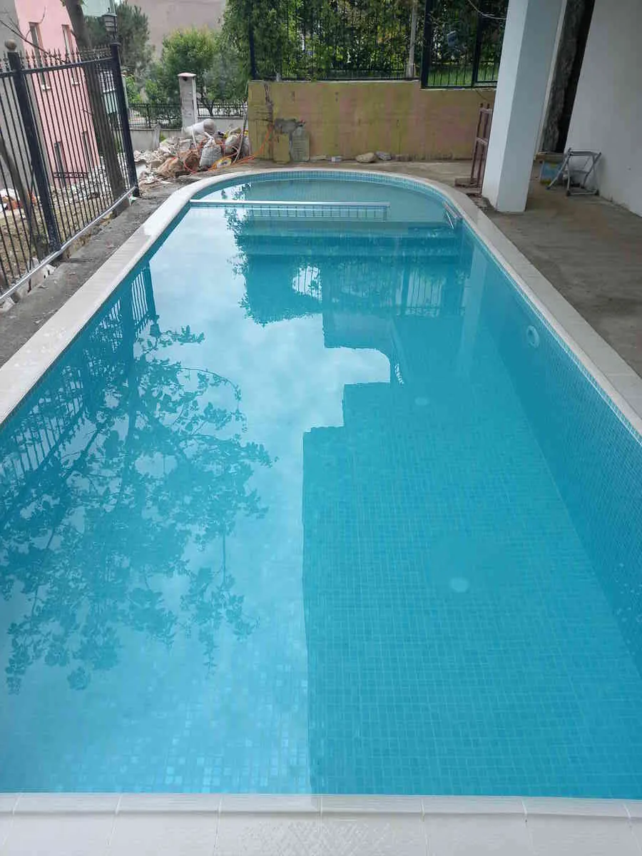 Safir mavisi suyu ve huzur veren atmosferiyle göz alıcı bir yüzme havuzu.